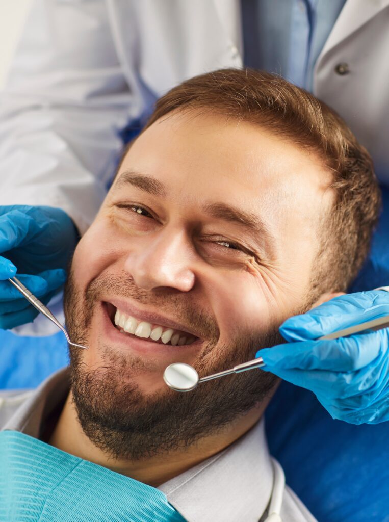 Happy man smiling toothily while being on medical check up in dentistry clinic