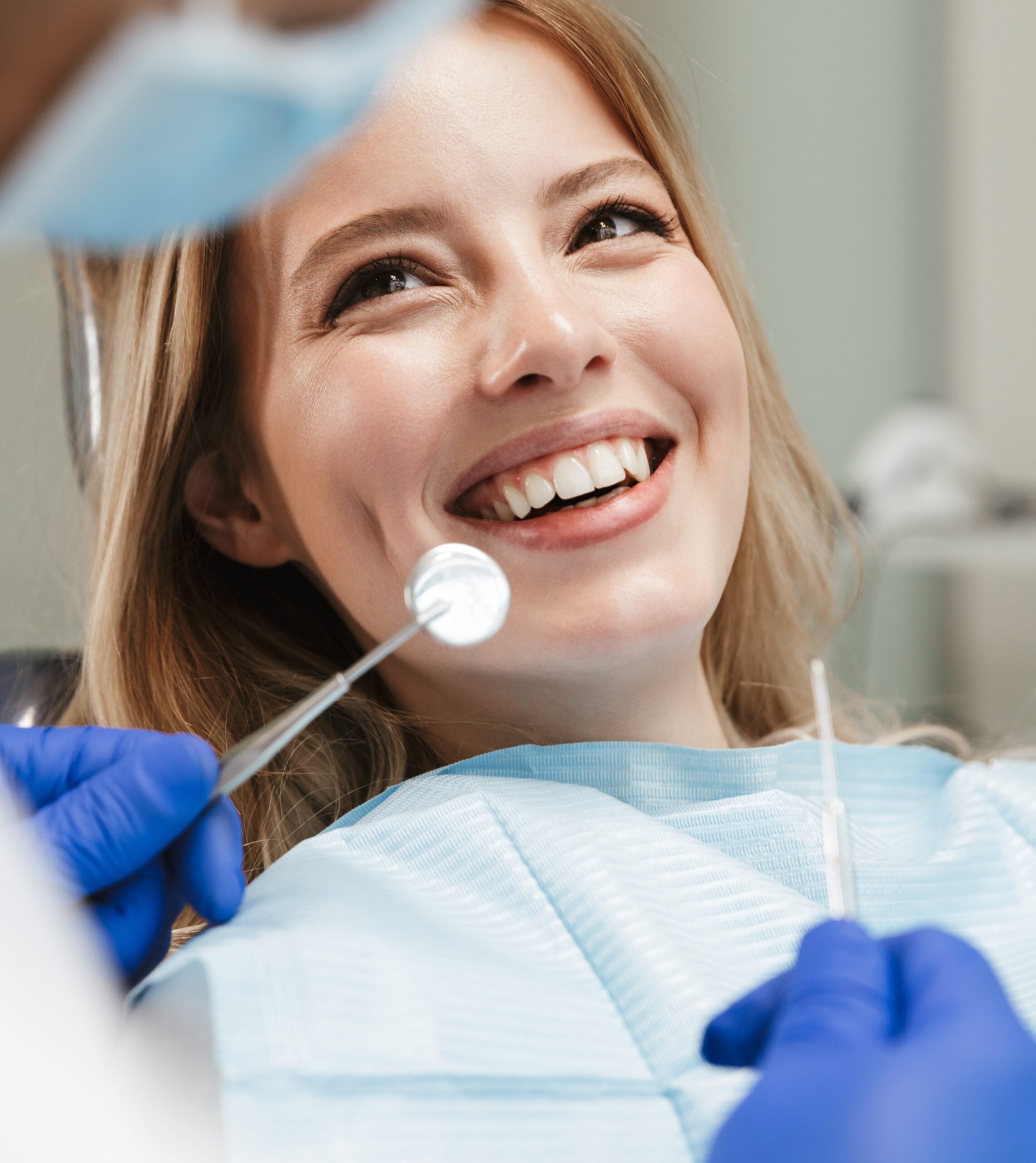 Image of pretty woman sitting in dental chair while aprofessional doctor fixing her teeth