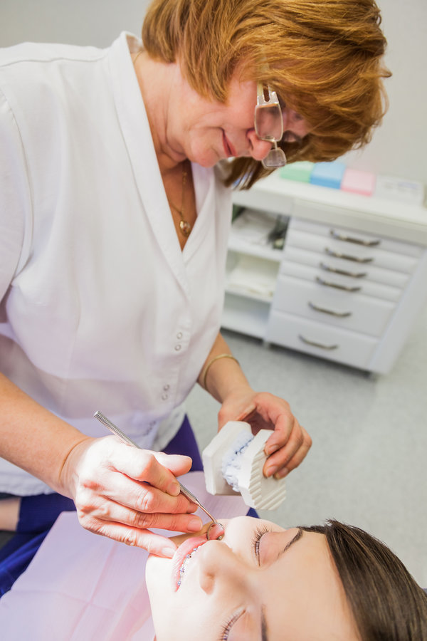Female Patient With Braces Having Her Teeth Exam By Specialist